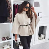 beige cape top met ceintuur en wijde mouwen, gecombineerd met zwarte broek en handtas