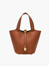 De Luna Lock Bag in Cognac, met hoogwaardig vegan leer, gouden accenten en een metalen slot. Afmetingen: 16 x 20 x 19 cm