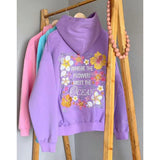 paarse hoodie met bloemendessin en quote op kledingrek met andere pastel hoodies