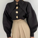 zwarte statement blouse met gouden sierknopen en extra grote kraag