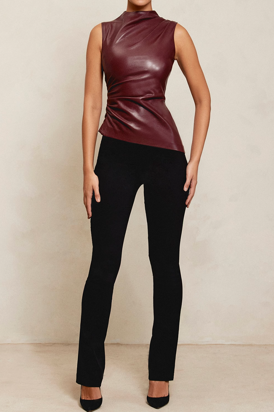 Bordeauxrode en zwarte faux leather top met asymmetrische snit, gemaakt van zacht PU-materiaal. Perfect voor edgy en elegante outfits.=-0p[;/