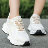 witte sportieve damessneakers met gele accenten en profielzool