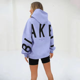 model draagt paarse oversized trui met print op rug