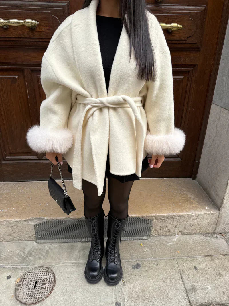 Witte winterjas met faux fur details aan de mouwen gecombineerd met laarzen
