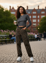 streetstyle: vrouw in grijze top met leopard jeans en witte sneakers in park