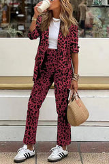 model draagt rode leopardprint tweedelige set met blazer en broek, gecombineerd met sneakers