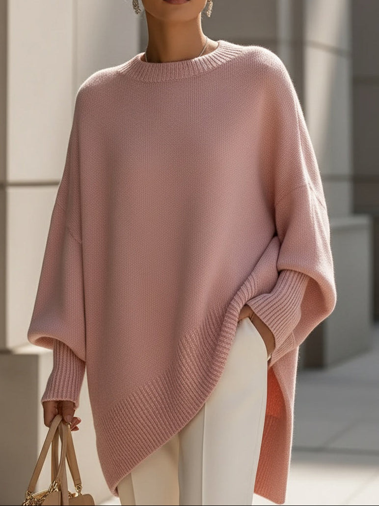 Roze oversized trui met ronde ribhals en brede ribzoom over een witte pantalon