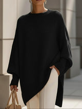 Zwarte oversized trui met vleermuismouwen en brede ribzoom over een witte broek