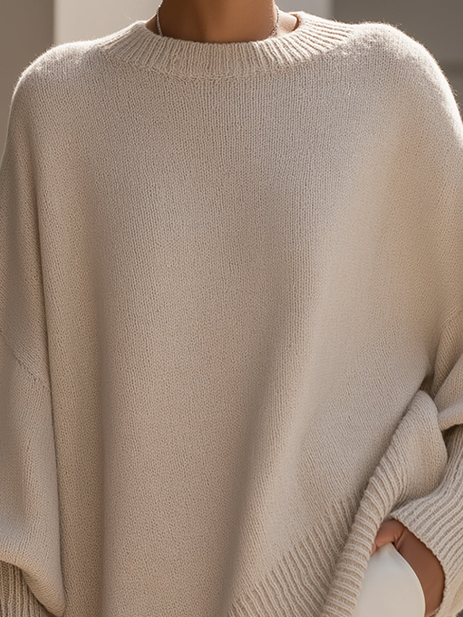 Detailfoto van de ronde ribgebreide hals en gedropte schouder van de beige gebreide trui