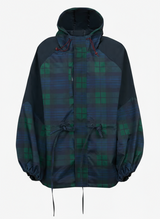 close-up van vrouw met capuchon in blauw-groene ruit regenjas