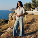 Dame draagt Harper wide leg jeans met witte blouse