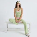 Dames matcha yoga set met halter top en flared broek, zittend op bankje