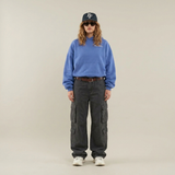 Blauwe oversized hoodie gedragen door model met pet en cargobroek, vooraanzicht