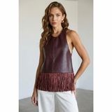 Bordeauxrode halter top van kunstleer met franjes langs de zoom, gedragen op een witte pantalon