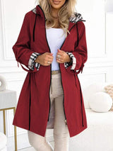 Rode trenchcoat voor dames met capuchon en ruitdetail bij mouwen.