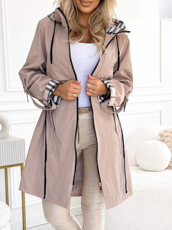 Beige trenchcoat met ruitvoering in de capuchon en manchetten.