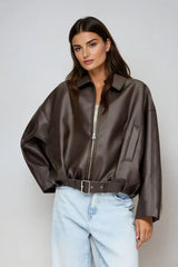 model draagt donkerbruine oversized vegan leren jas met rits en taille-riem