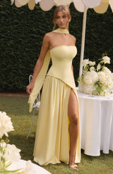 Model met gele strapless zomerjurk in tuinsetting