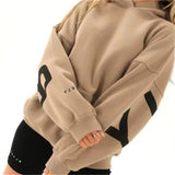model draagt bruine oversized trui met print op rug