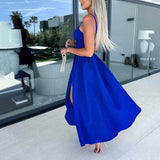 kobaltblauwe jurk met cut-out en split, gedragen met clutch