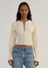 beige cardigan met knopen en brede tailleband, gedragen met jeans